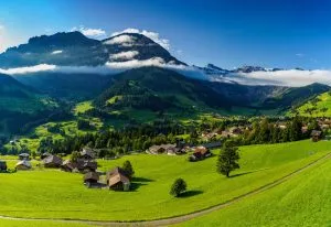 Panorama di Adelboden con cascine alpine, alberi, boschi e prati verdi