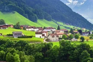 Kaunis näkymä idylliseen vuoristomaisemaan Alpeilla, jossa on perinteisiä mökkejä lähellä Altdorfin kaupunkia.